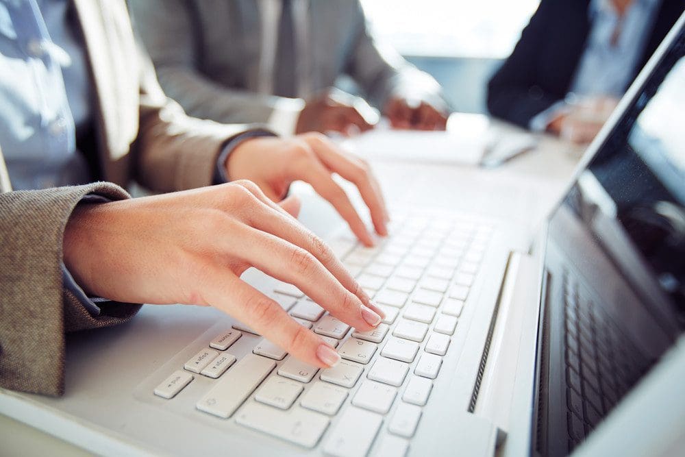 Woman typing on a laptop - OrthoSynetics