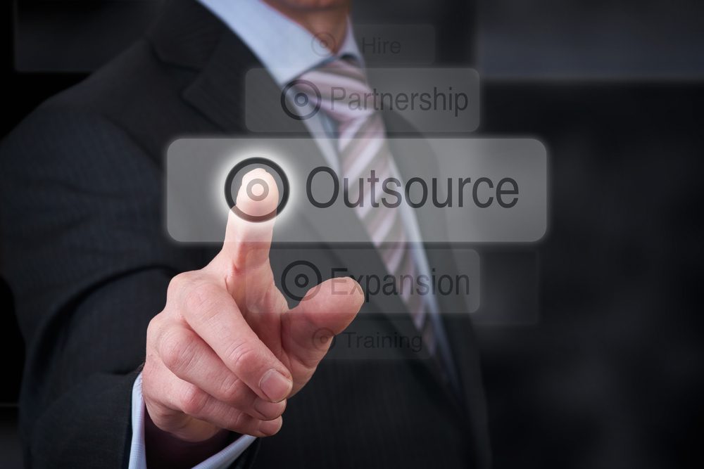 A businessman Pointing to a business outsourcing button on a clear screen.