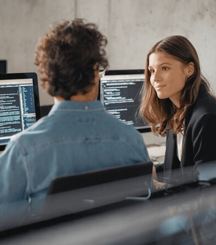 man and woman talking by computers